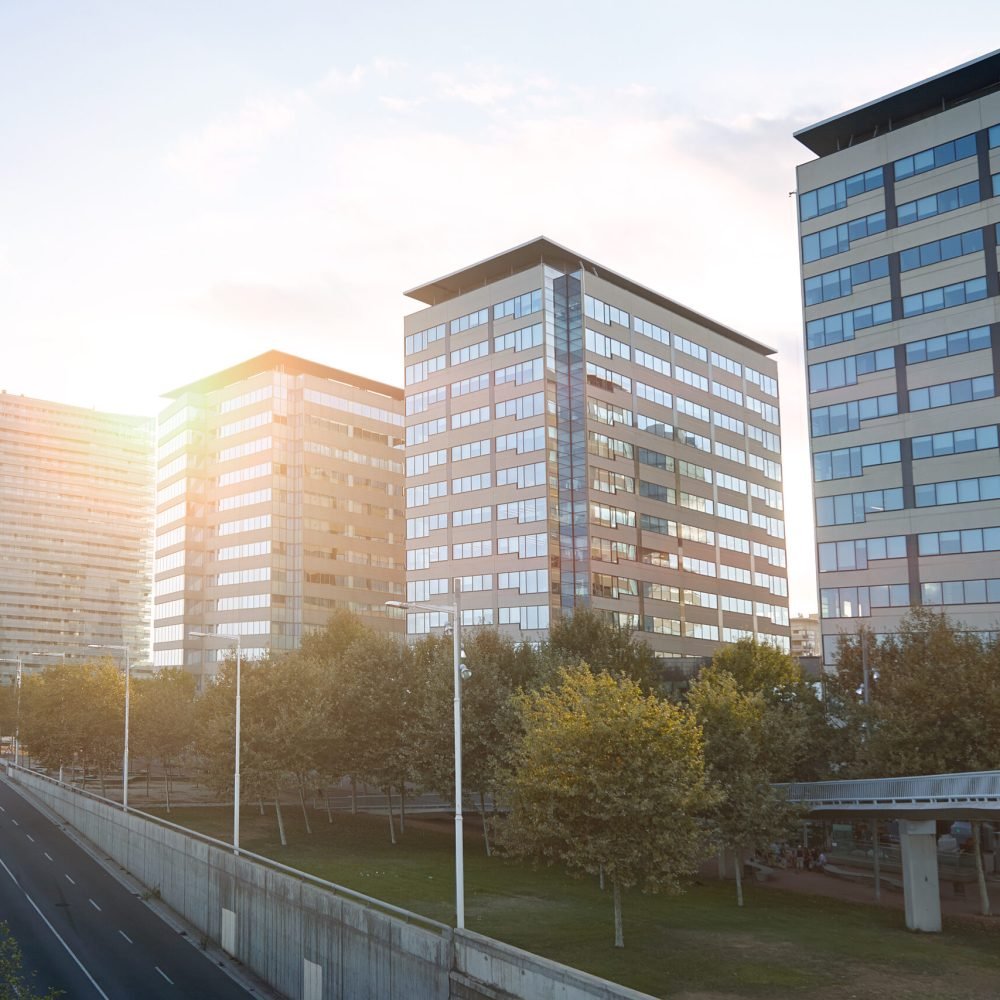 High rise city buildings along a highway shot at sunset.