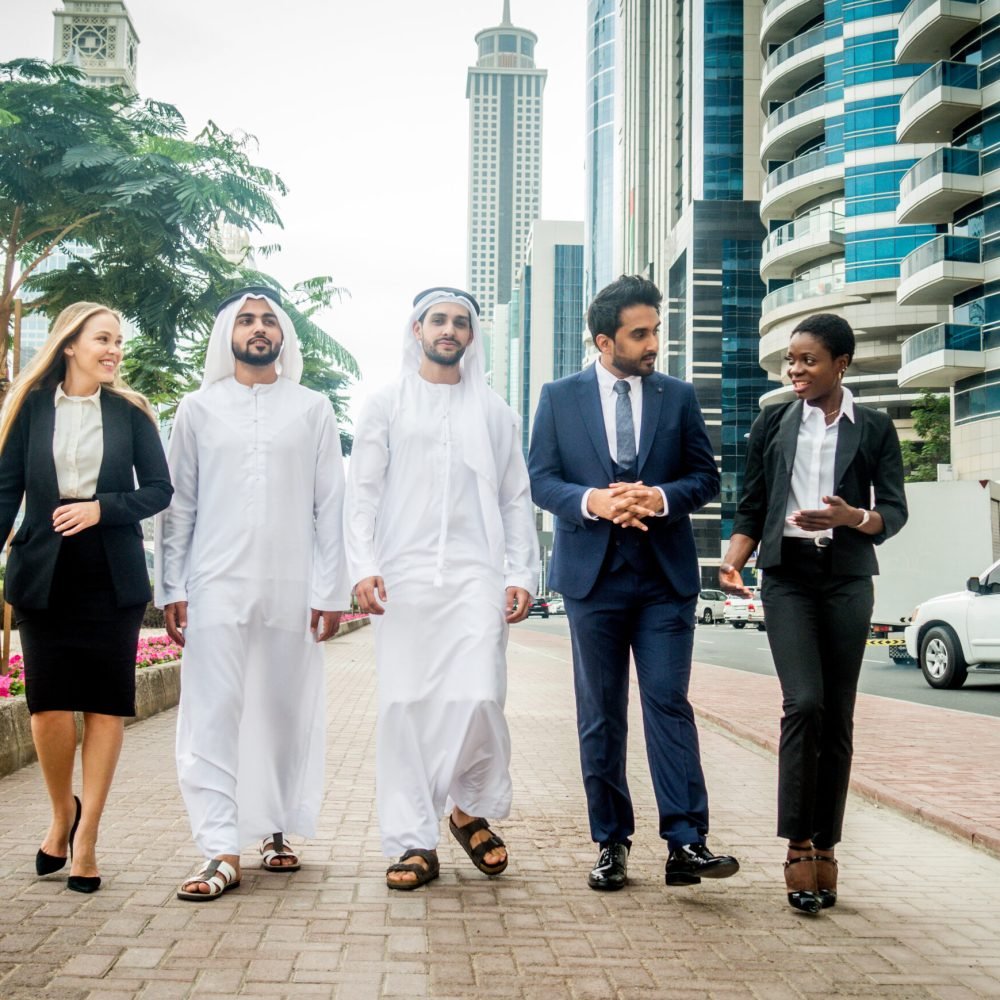 Multi-ethnic group of people on a business meeting in the UAE - Business people walking outdoors and talking about business
