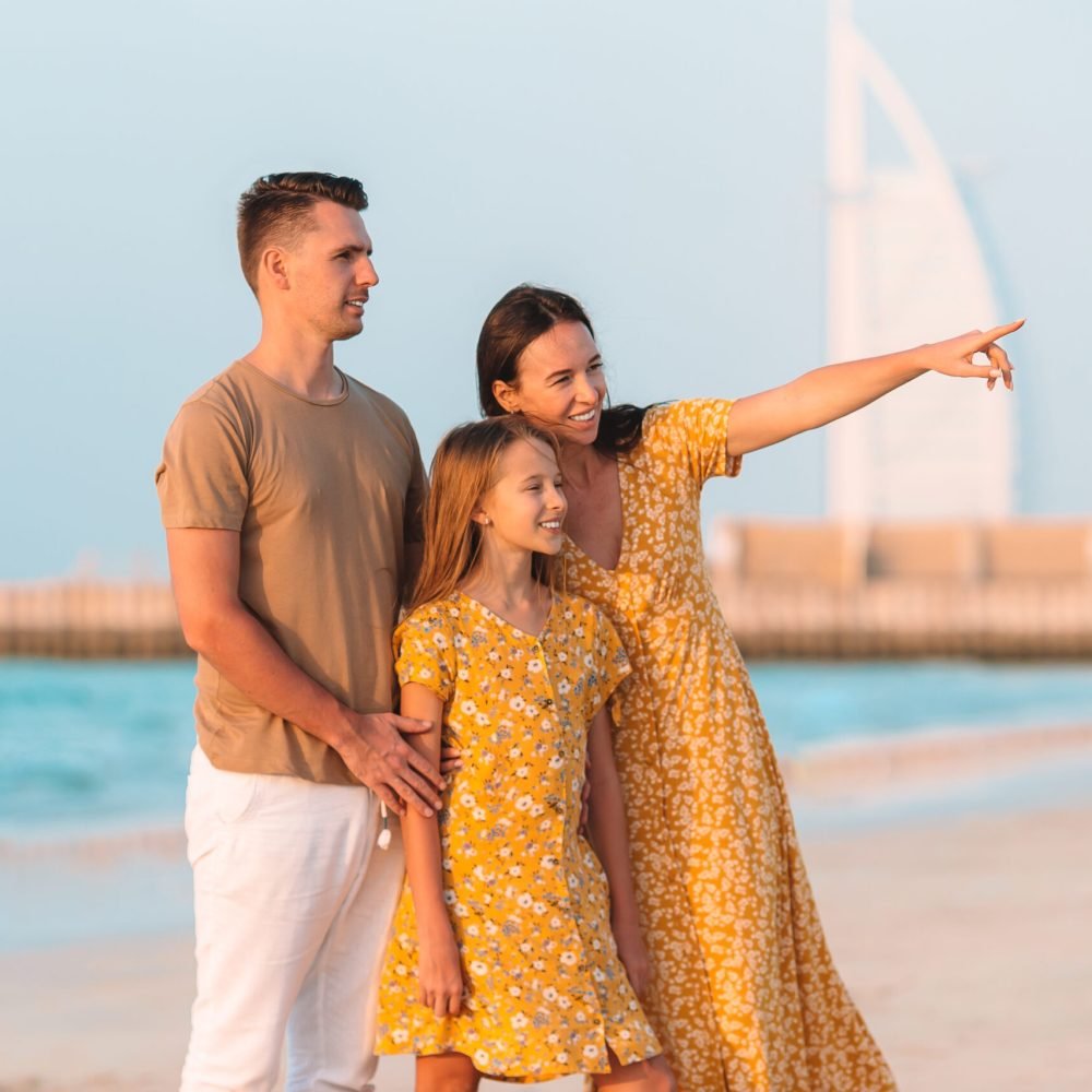 Happy family on the beach at summer vacation in Dubai, UAE. United Arab Emirates famous tourist destination.