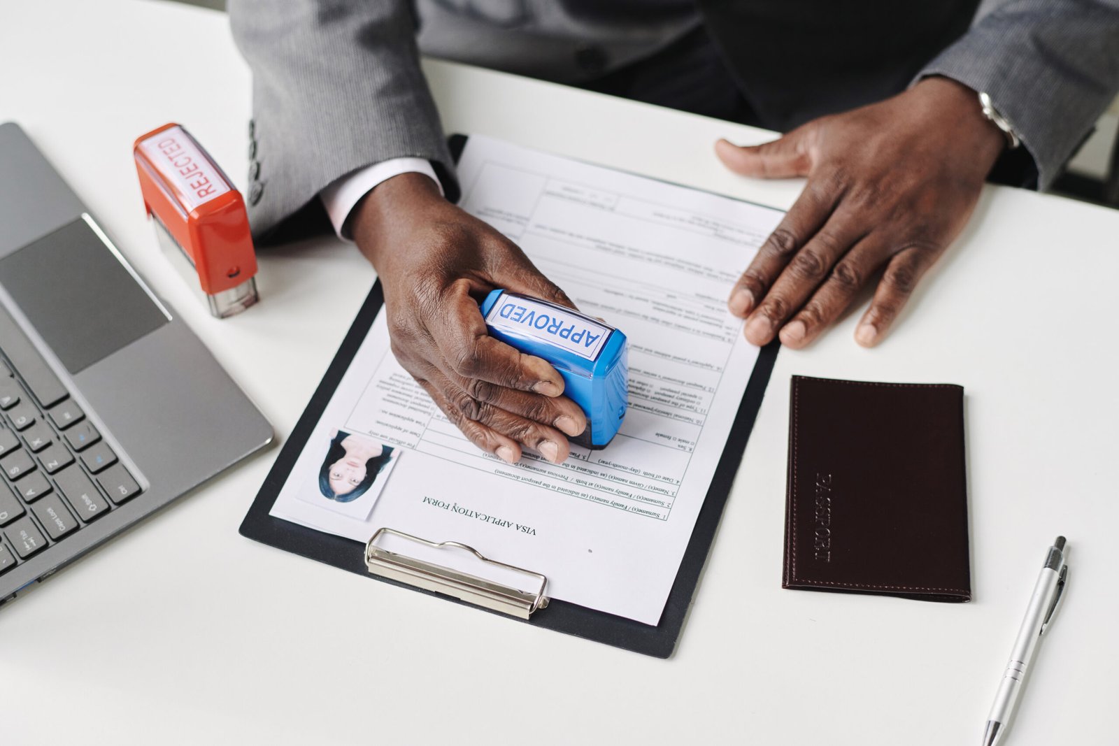 Man approving visa in office High angle view of African American man approving visa in office